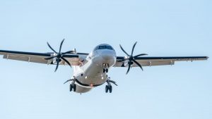 Close-up of an ATR 72 aircraft landing in Manises, Valencia, clear sky background.