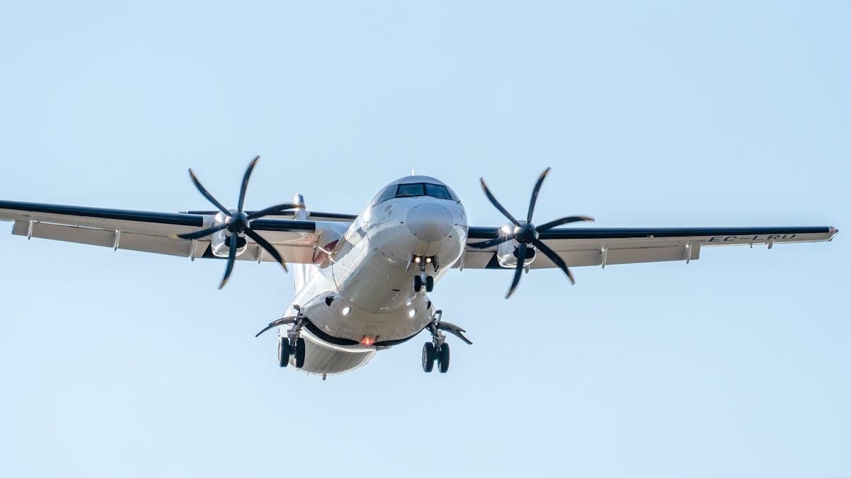 Close-up of an ATR 72 aircraft landing in Manises, Valencia, clear sky background.